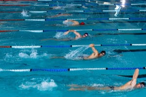 bañistas nadando en piscina olímpica